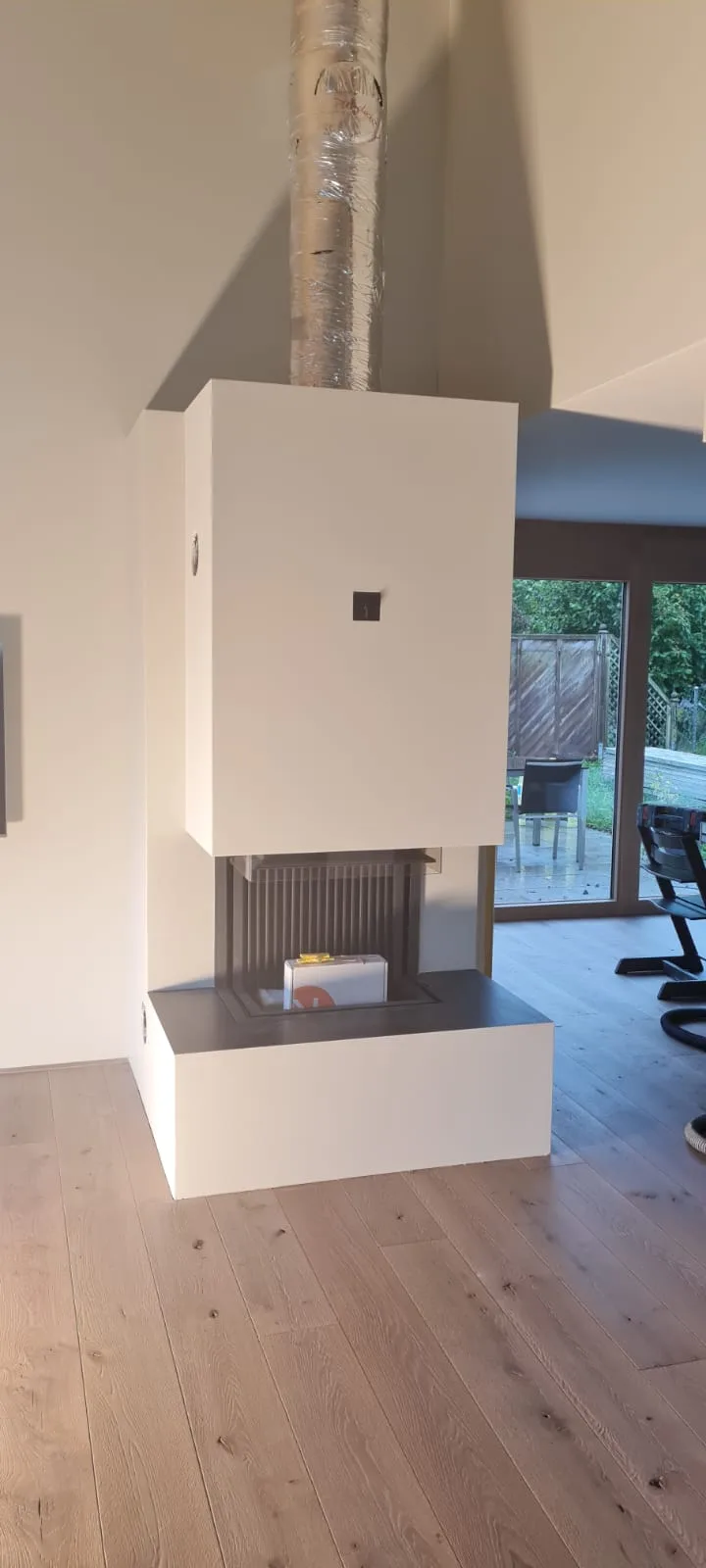Cheminée mit frisch verputzter Verkleidung im Wohnraum
