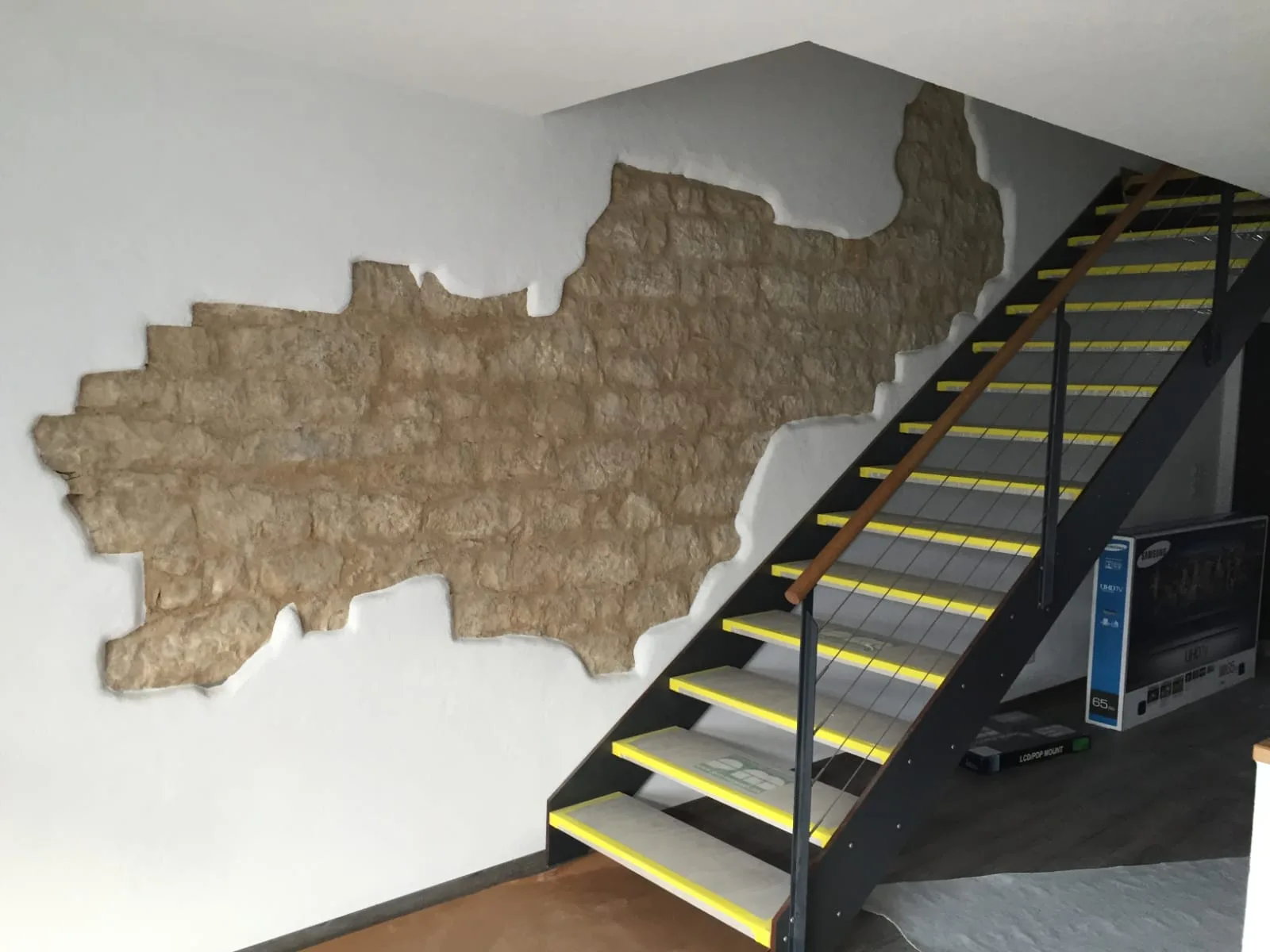 Freigelegtes Sichtmauerwerk als dekoratives Wandelement neben Treppe
